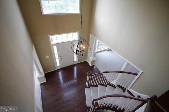  - entrance foyer featuring a towering ceiling, wood finished floors, and a chandelier