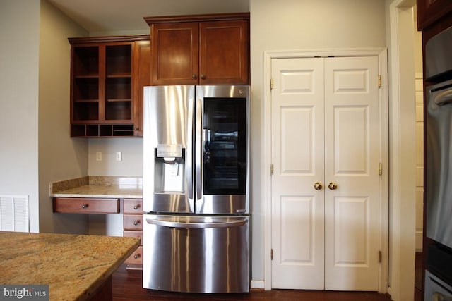  - kitchen with appliances with stainless steel finishes and light stone countertops