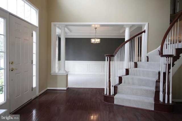  - entryway featuring decorative columns, stairs, wood-type flooring, a chandelier, and crown molding