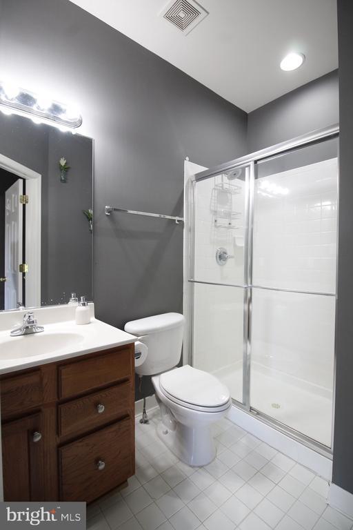  - bathroom featuring vanity, a stall shower, and tile patterned floors