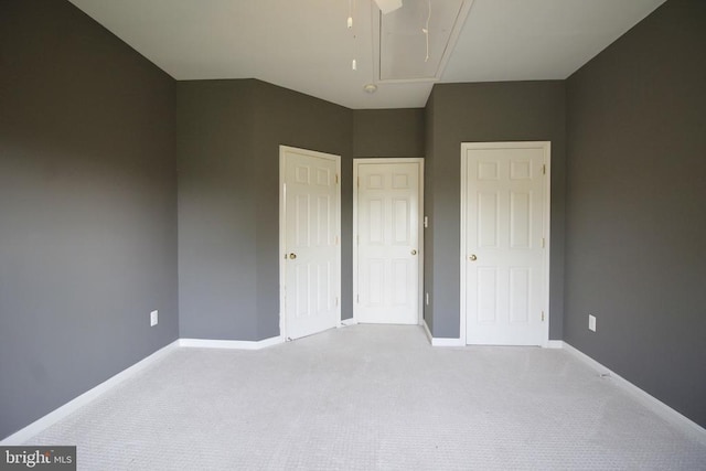  - unfurnished bedroom with attic access and carpet flooring