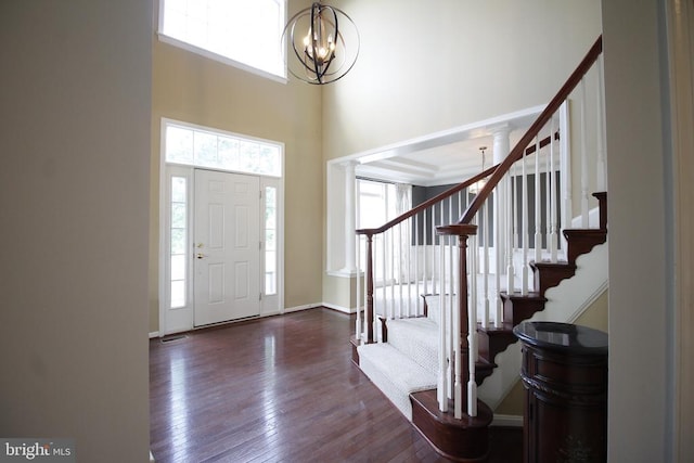  - foyer with a chandelier, healthy amount of natural light, hardwood / wood-style flooring, and a towering ceiling