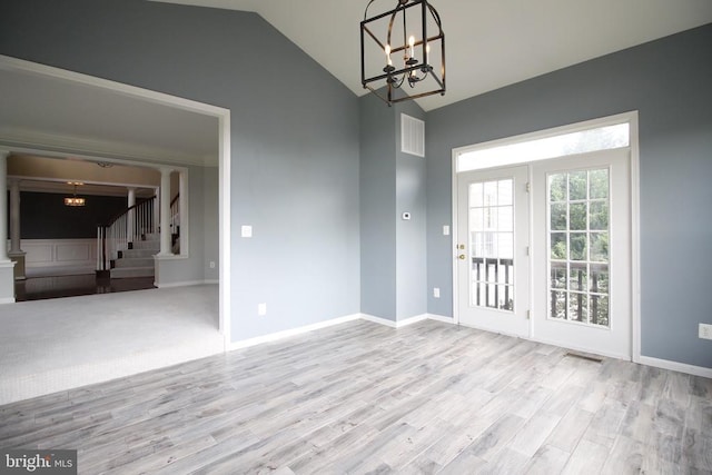  - interior space with a chandelier, wood finished floors, lofted ceiling, and stairway