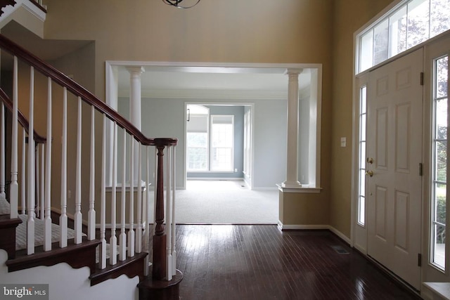  - foyer entrance featuring ornate columns, stairway, ornamental molding, and wood-type flooring
