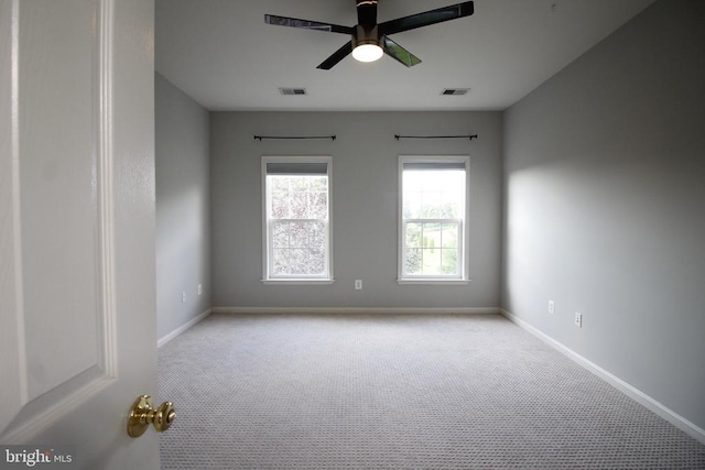  - carpeted spare room with a ceiling fan and baseboards