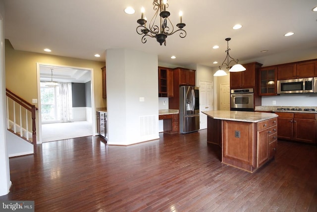  - kitchen featuring dark wood-style floors, stainless steel appliances, a chandelier, a center island, and recessed lighting