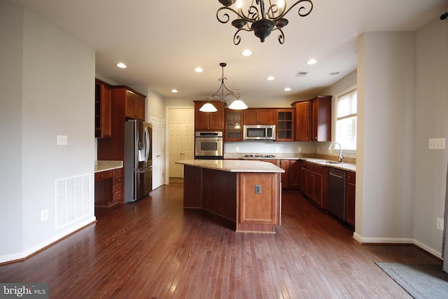  - kitchen featuring a chandelier, dark wood-style floors, appliances with stainless steel finishes, a kitchen island, and recessed lighting