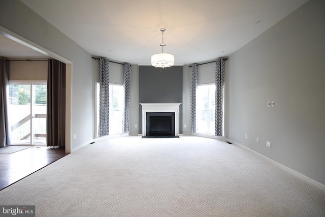  - unfurnished living room with healthy amount of natural light, a fireplace, and carpet flooring