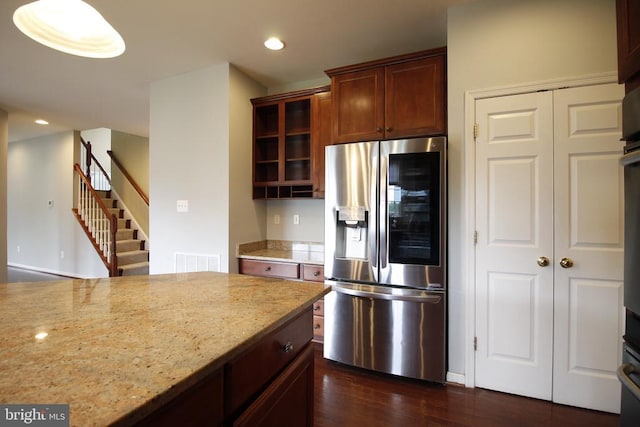  - kitchen with stainless steel fridge, dark wood-style floors, light stone countertops, recessed lighting, and glass insert cabinets