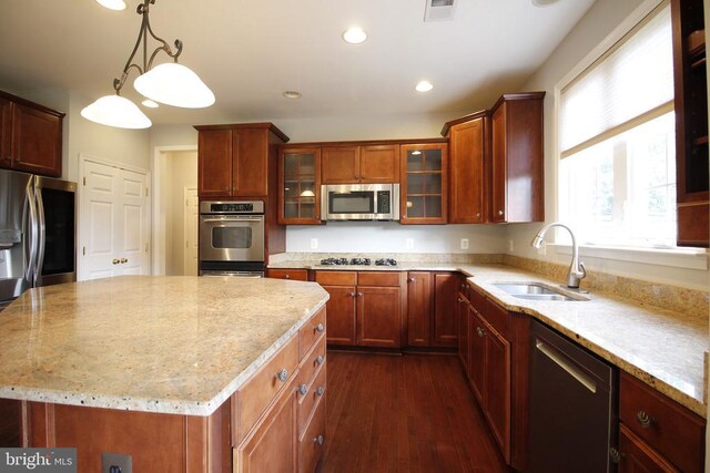  - kitchen with appliances with stainless steel finishes, light stone countertops, dark wood finished floors, glass insert cabinets, and recessed lighting