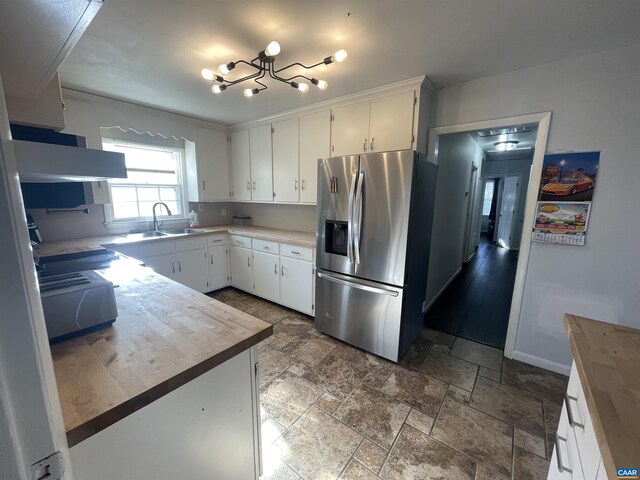 3133 Burnley Station Rd, Barboursville, VA 22923 - kitchen with stainless steel fridge, a sink, white cabinetry, a chandelier, and baseboards