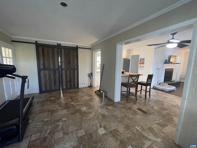 3133 Burnley Station Rd, Barboursville, VA 22923 - entryway with a barn door, ornamental molding, stone tile flooring, a fireplace, and plenty of natural light