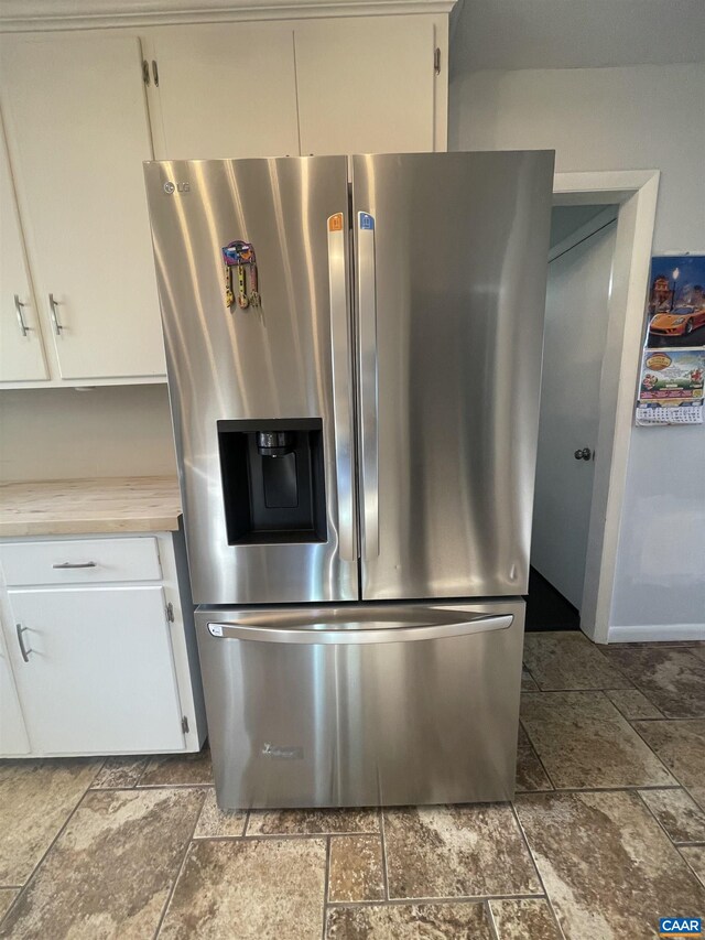 3133 Burnley Station Rd, Barboursville, VA 22923 - kitchen featuring stainless steel refrigerator with ice dispenser, stone tile floors, light countertops, and white cabinetry