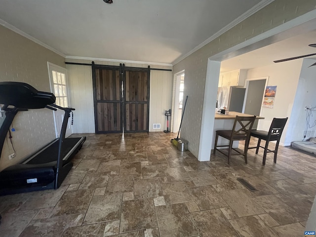 3133 Burnley Station Rd, Barboursville, VA 22923 - entrance foyer with stone tile floors, a barn door, ornamental molding, and a ceiling fan