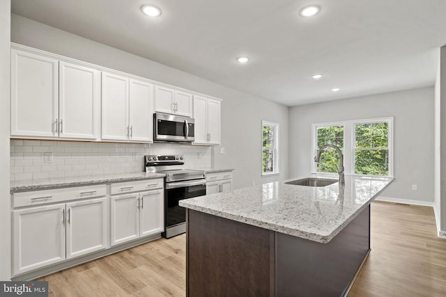 150 Holly Ct, Mineral, VA 23117 - kitchen with appliances with stainless steel finishes, a sink, backsplash, light wood finished floors, and white cabinetry