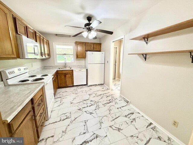 kitchen with white appliances, a sink, light marble finish flooring, a ceiling fan, and brown cabinets
