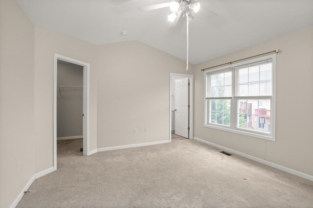 2890 Crystal Spring Ln, Rockingham, VA 22801 - unfurnished bedroom with carpet floors, a walk in closet, baseboards, vaulted ceiling, and a closet