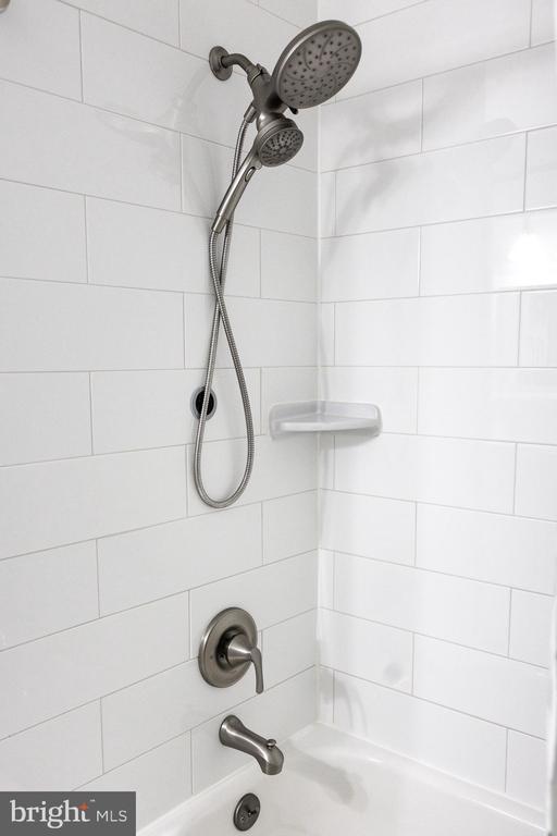 bathroom view of washtub / shower combination