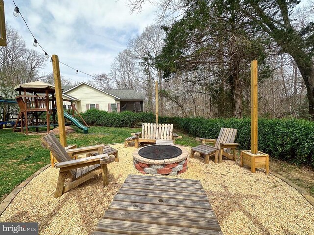 view of patio with an outdoor fire pit and a playground