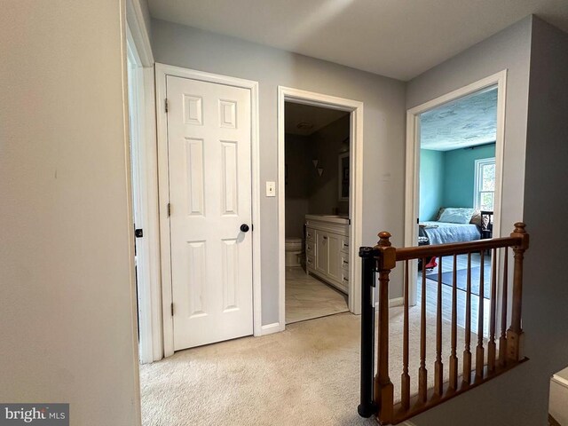 hallway with light carpet and baseboards
