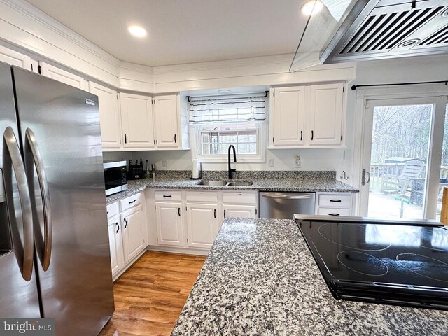 kitchen featuring stainless steel appliances, a sink, plenty of natural light, white cabinets, and recessed lighting