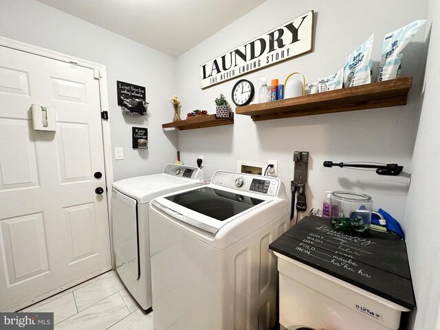 laundry room featuring washing machine and dryer and light marble finish flooring