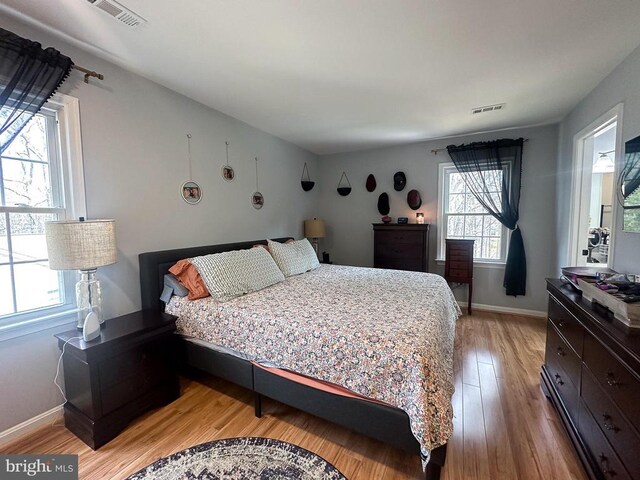 bedroom with light wood-style flooring and baseboards