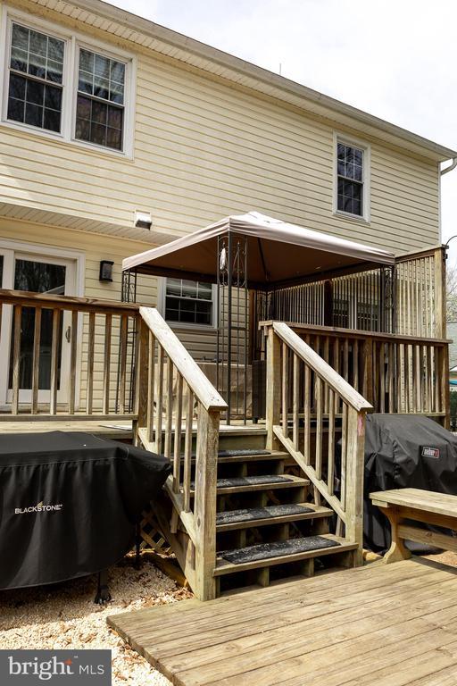 wooden terrace featuring stairs and a grill