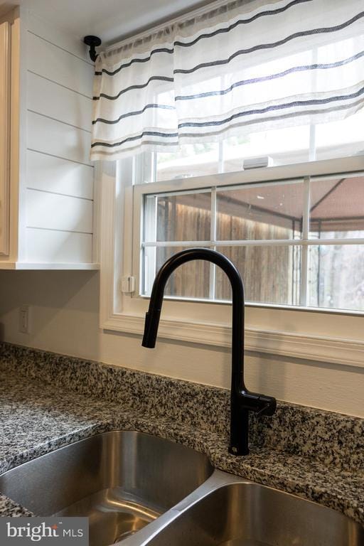 kitchen view of a sink and dark stone counters