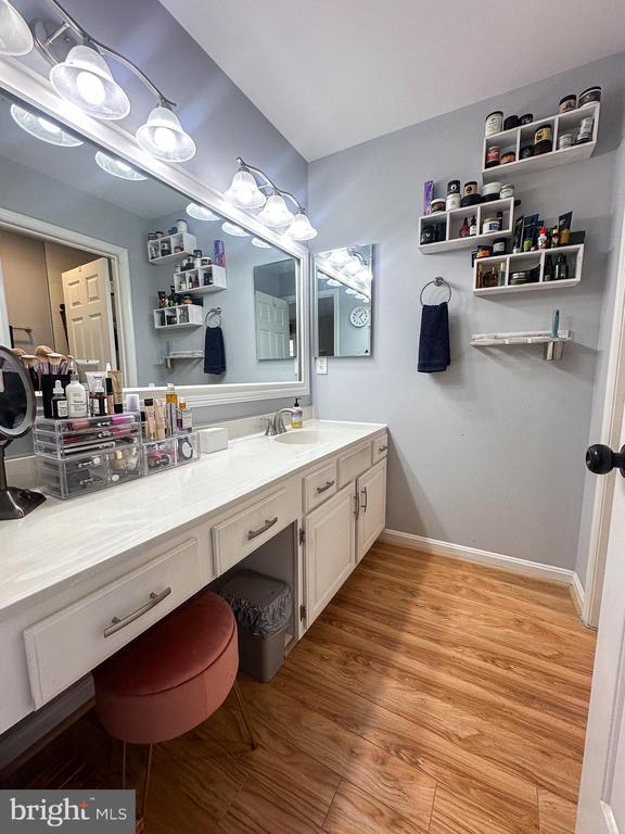 bathroom featuring wood finished floors, vanity, and baseboards
