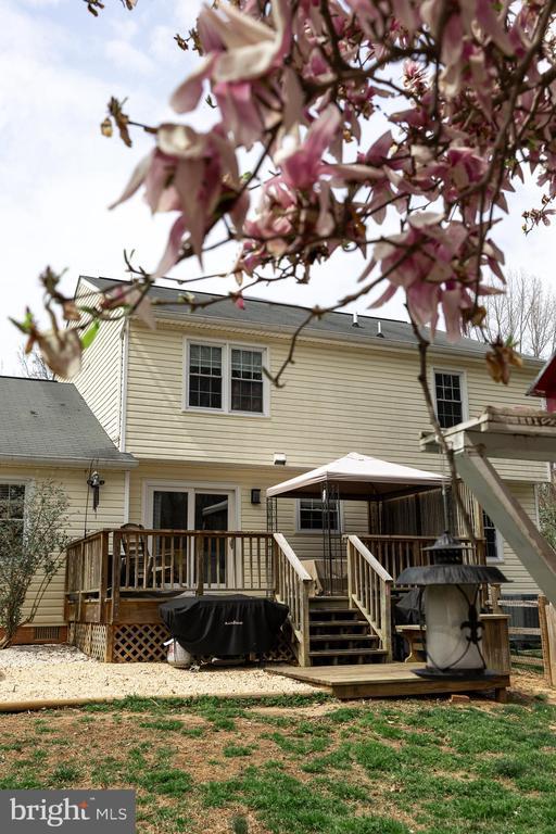 rear view of house with a gazebo and a deck