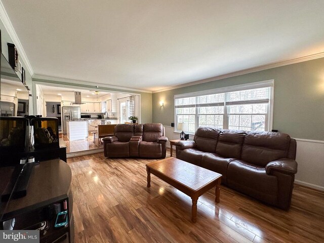 living room featuring wood finished floors and crown molding