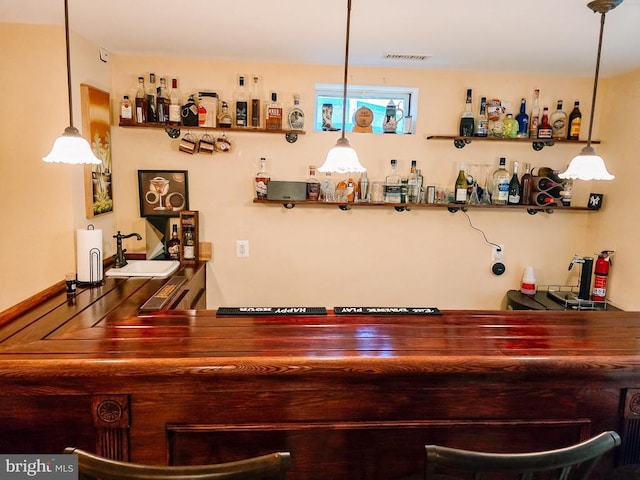  - indoor dry bar featuring decorative light fixtures