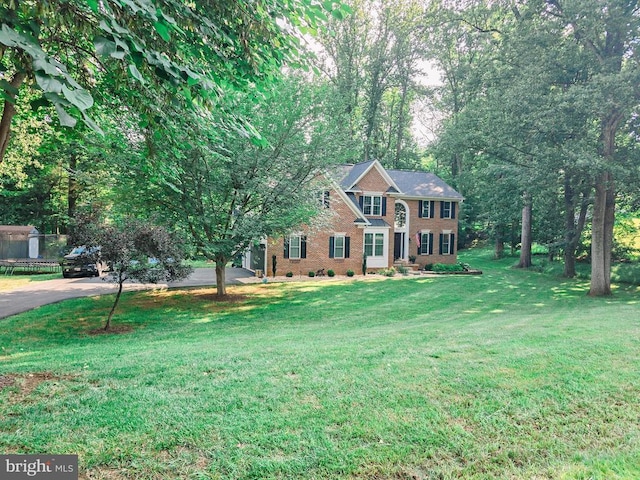  - view of front facade featuring brick siding, a front lawn, and driveway