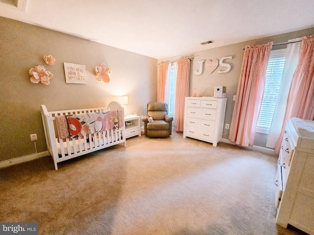  - carpeted bedroom featuring multiple windows and a crib