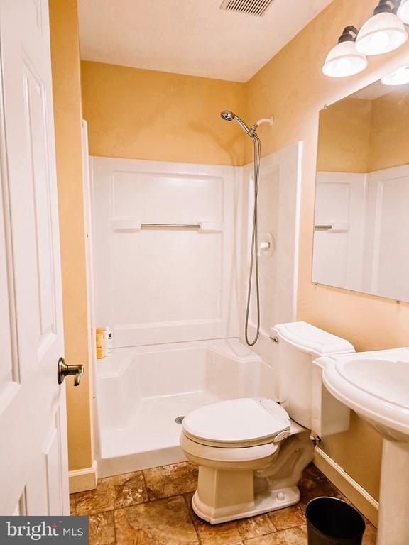  - bathroom with a stall shower and stone finish flooring