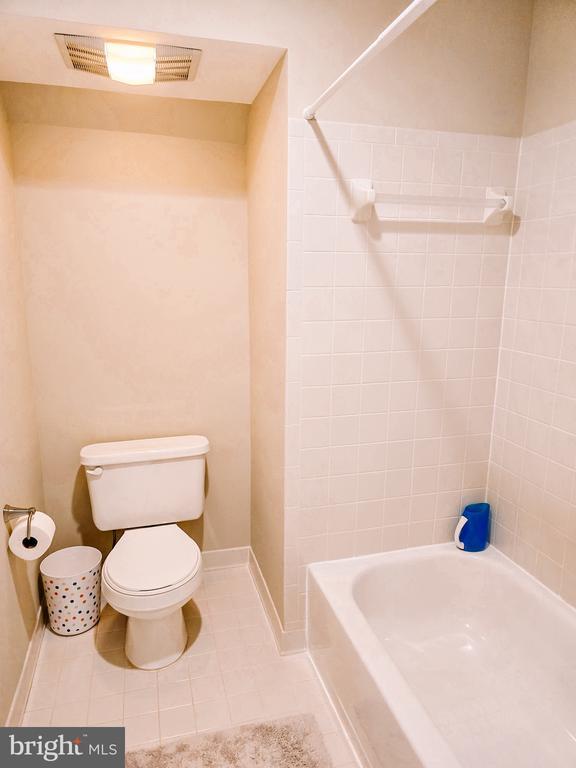  - bathroom featuring tile patterned flooring and washtub / shower combination