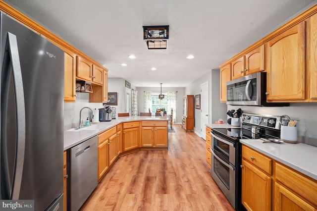 108 Shannon Glen Ct, Louisa, VA 23093 - kitchen with stainless steel appliances, a peninsula, light wood-style floors, recessed lighting, and light countertops