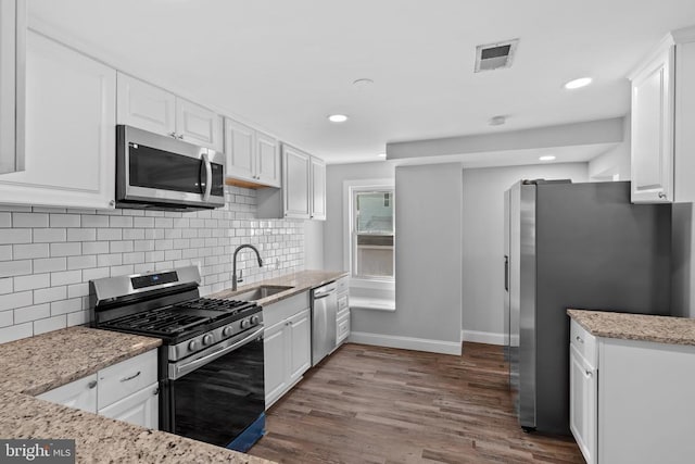 63 Madison St, Warrenton, VA 20186 - kitchen featuring stainless steel appliances, white cabinets, dark wood finished floors, light stone countertops, and backsplash