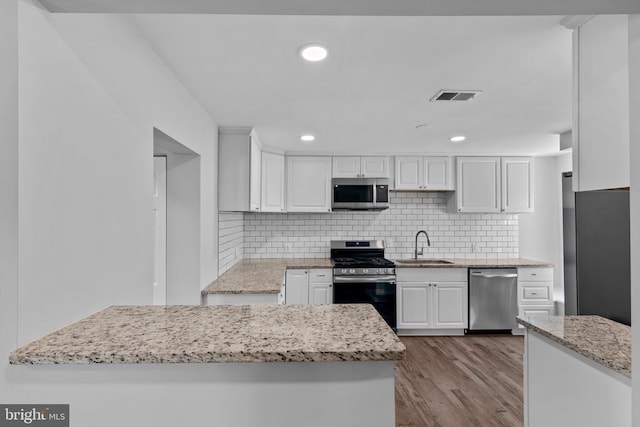 63 Madison St, Warrenton, VA 20186 - kitchen featuring stainless steel appliances, white cabinets, decorative backsplash, wood finished floors, and recessed lighting