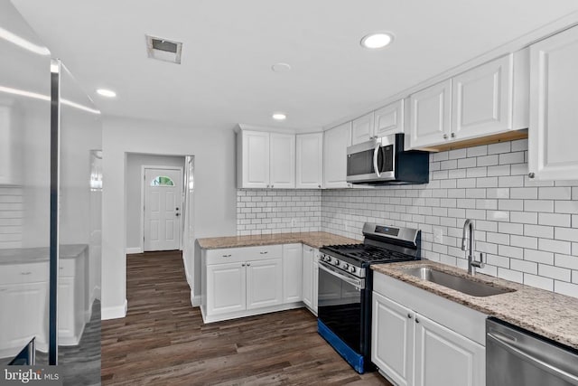 63 Madison St, Warrenton, VA 20186 - kitchen with stainless steel appliances, dark wood-style floors, white cabinets, decorative backsplash, and recessed lighting