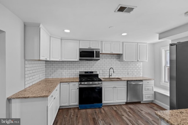 63 Madison St, Warrenton, VA 20186 - kitchen featuring stainless steel appliances, white cabinets, dark wood-type flooring, backsplash, and recessed lighting