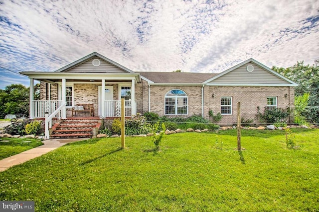 single story home featuring brick siding, a porch, and a front yard