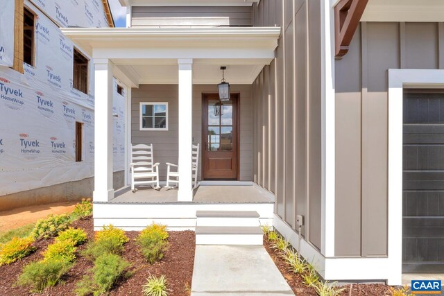 doorway to property with a porch and board and batten siding