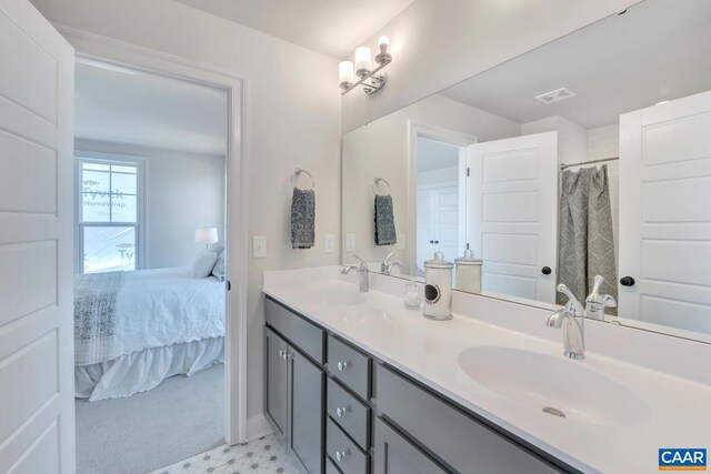 full bath with double vanity, connected bathroom, visible vents, and a sink