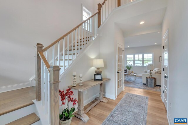 staircase featuring french doors, wood finished floors, baseboards, and recessed lighting