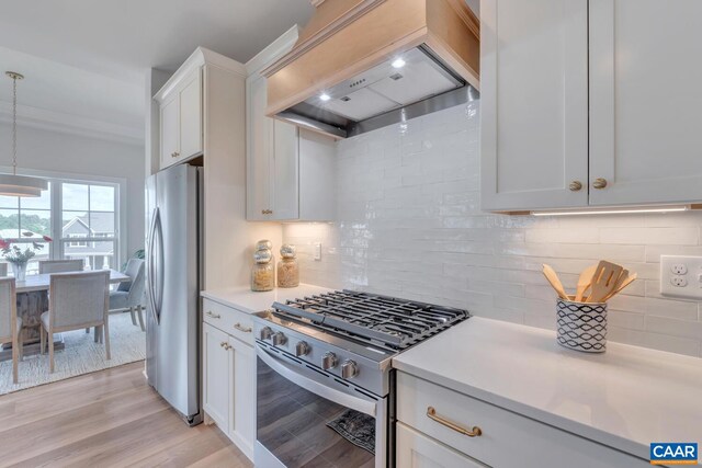 kitchen featuring decorative backsplash, light countertops, custom range hood, and appliances with stainless steel finishes