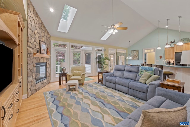143 Chapel Ct, Palmyra, VA 22963 - living room with light wood finished floors, high vaulted ceiling, a skylight, a fireplace, and a ceiling fan