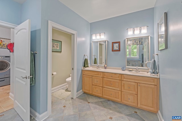 143 Chapel Ct, Palmyra, VA 22963 - bathroom with washer / clothes dryer, toilet, double vanity, and baseboards