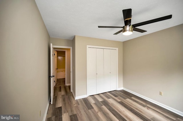 141 Eagle Ct, Locust Grove, VA 22508 - unfurnished bedroom featuring dark wood-style floors, baseboards, a closet, a ceiling fan, and a textured ceiling